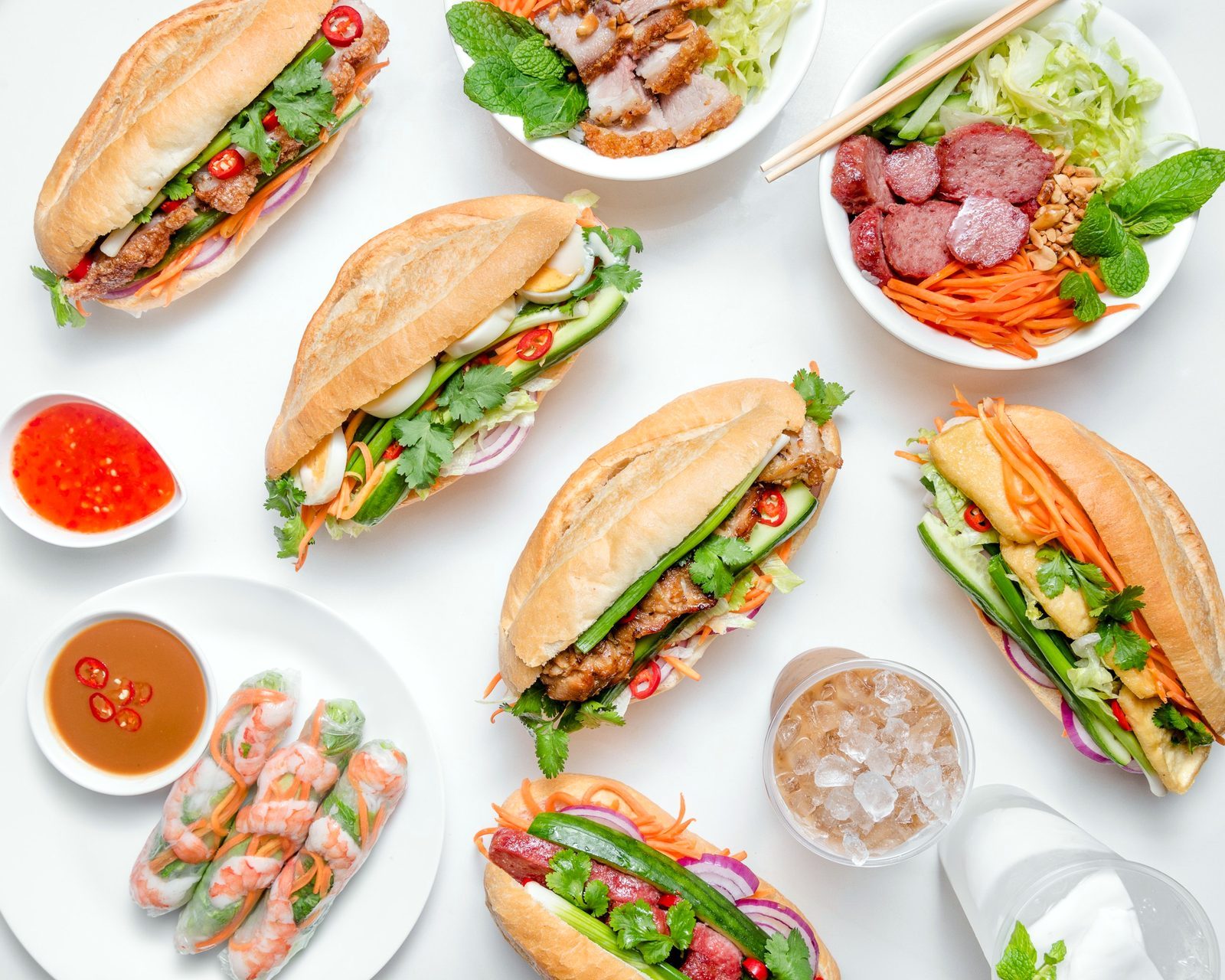 A spread of Roll House banh mi, vermicelli bowls, prawn rice paper rolls and iced coffee